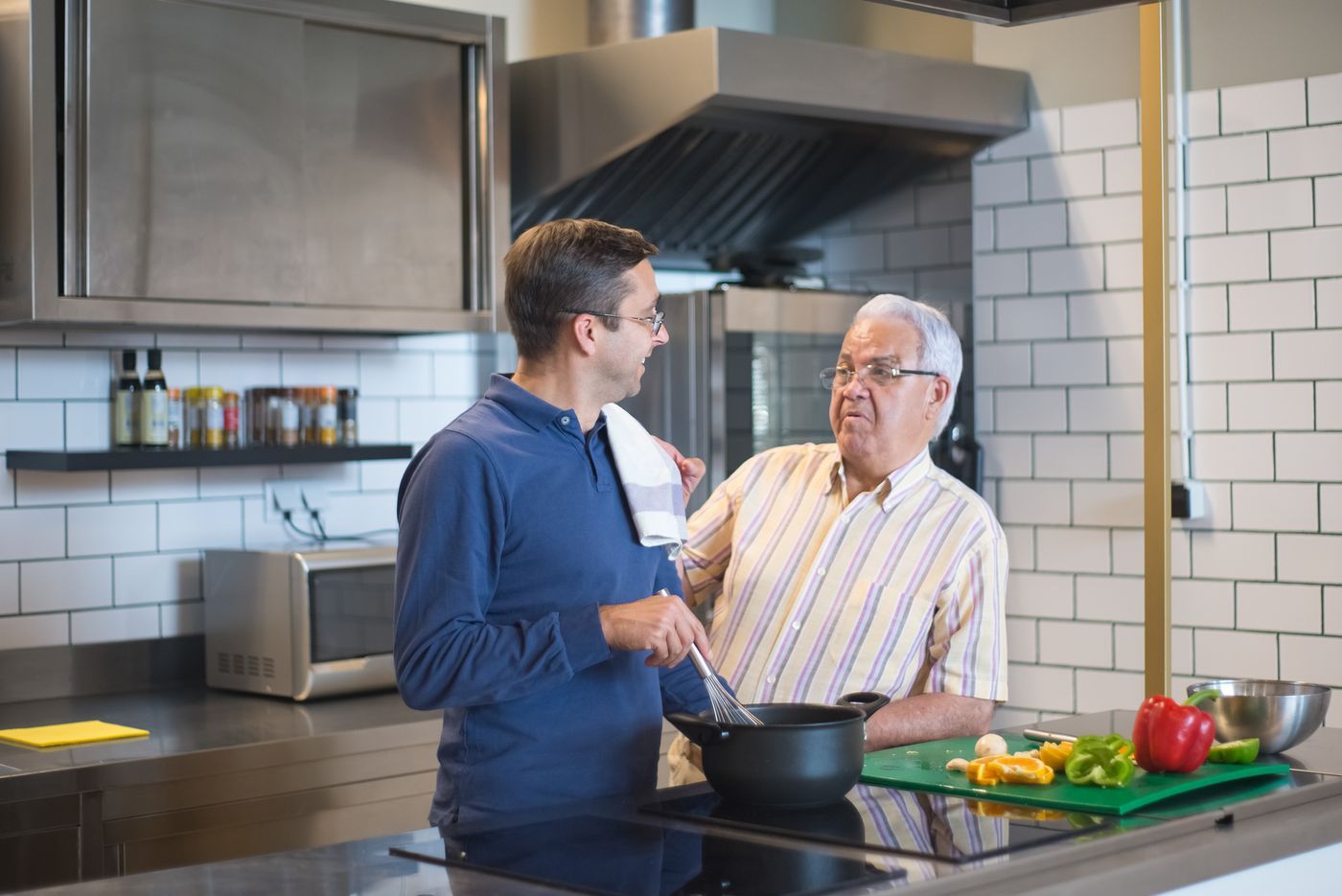 Adult son cooking with his father