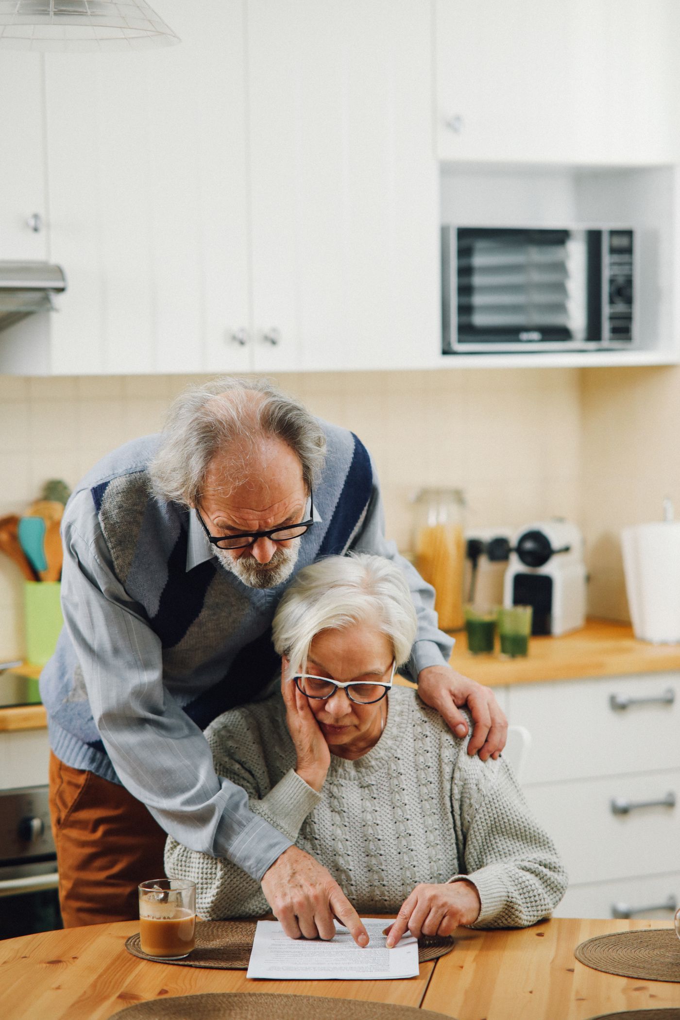 Senior couple reviewing documents at the kitchen table